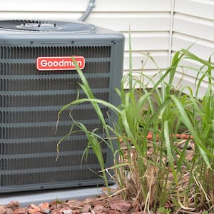 An air conditioning unit sits outside a home.